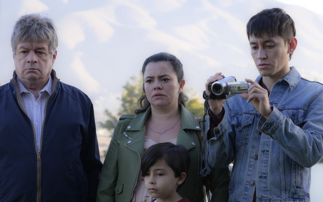 Fotograma de Amores incompletos: José junto a su familia, un joven graba con una cámara de video