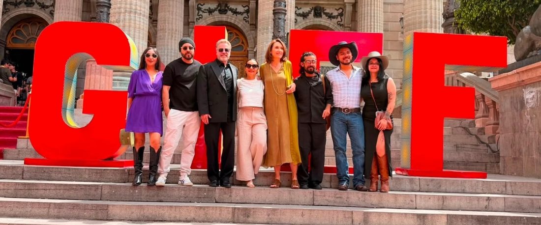 El equipo de Bailando solo posa frente a las letras rojas del GIFF en la escalinata del Teatro Juárez de Guanajuato