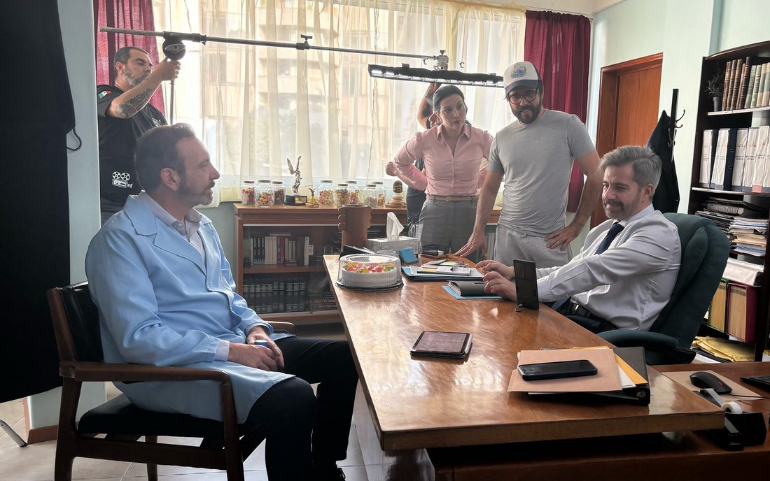 Rodaje de Bailando solo: el equipo prepara una escena en una oficina con dos actores sentados al escritorio